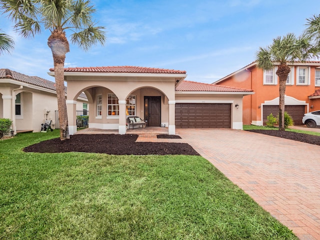 mediterranean / spanish-style house with a garage, a front lawn, and covered porch