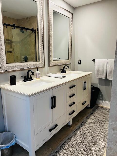 bathroom featuring double vanity and walk in shower