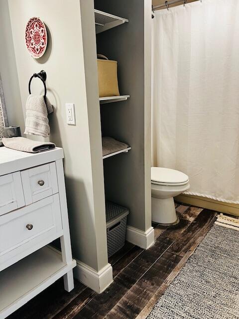 bathroom with wood-type flooring, vanity, and toilet