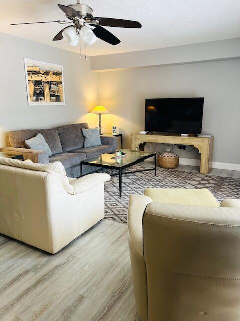 living room with ceiling fan and light hardwood / wood-style floors