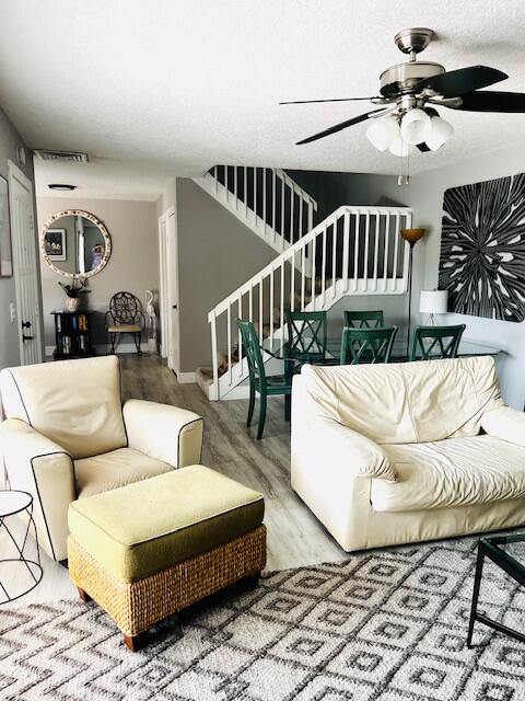 living room featuring ceiling fan and hardwood / wood-style flooring