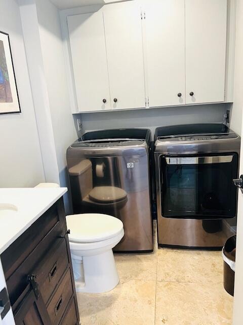 clothes washing area with light tile patterned floors and washer and dryer