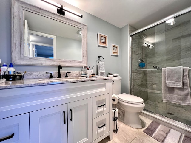 bathroom with hardwood / wood-style floors, vanity, toilet, and a shower with door