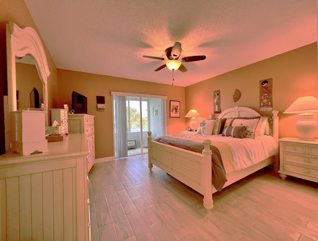 bedroom featuring ceiling fan, light hardwood / wood-style floors, access to exterior, and a textured ceiling