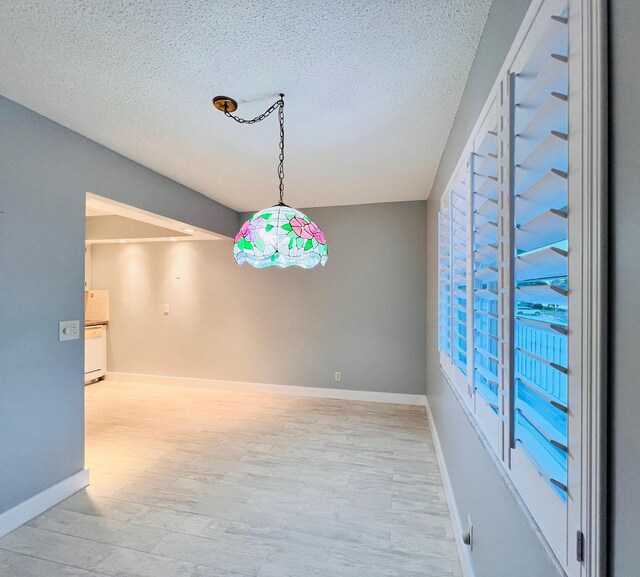 dining room featuring a textured ceiling and light wood-type flooring