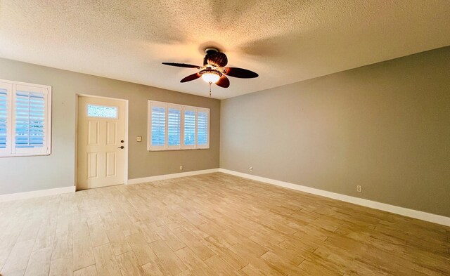 living room with a textured ceiling, a wealth of natural light, and light hardwood / wood-style flooring