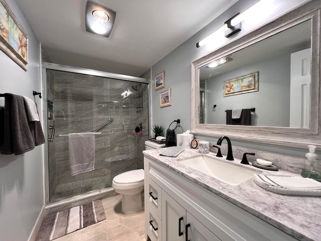 bathroom featuring tile patterned floors, vanity, toilet, and an enclosed shower