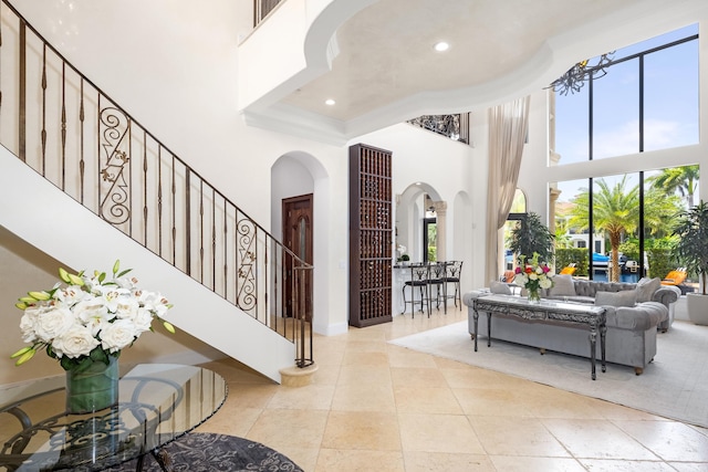 tiled foyer entrance with a healthy amount of sunlight and a high ceiling