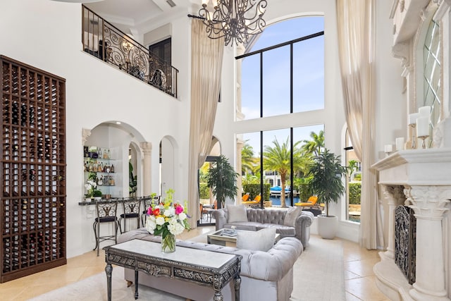 living room featuring a healthy amount of sunlight, a towering ceiling, and a chandelier