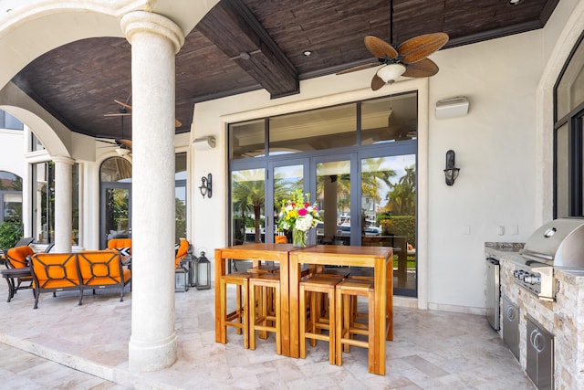 view of patio with grilling area, ceiling fan, and exterior kitchen