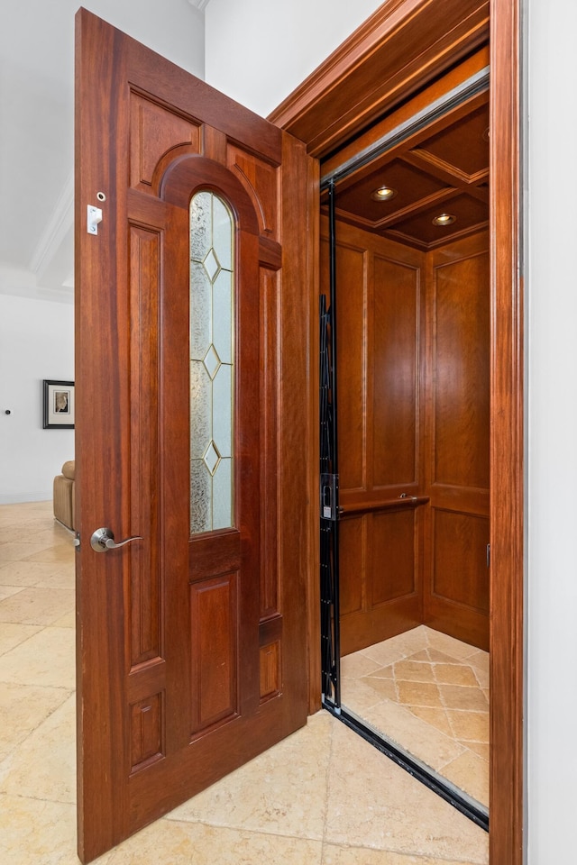 entrance foyer with tile patterned floors and ornamental molding