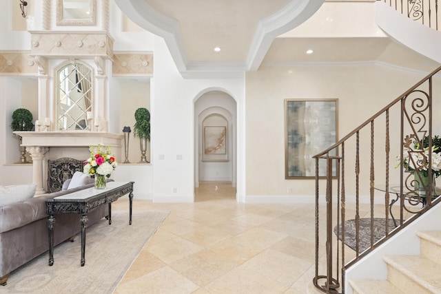 tiled foyer entrance with ornamental molding and a high end fireplace