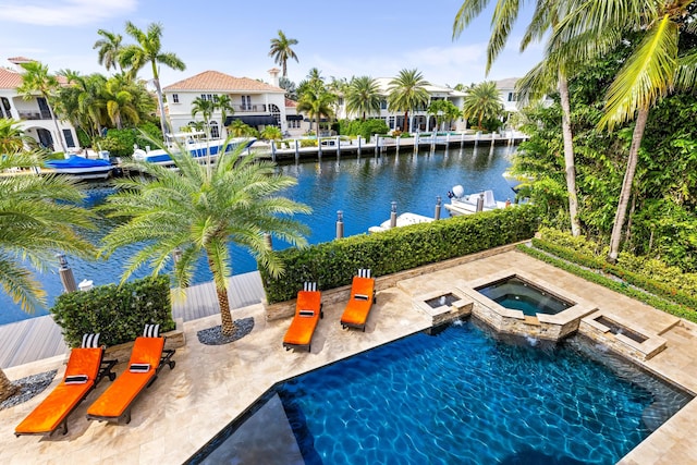 view of swimming pool featuring an in ground hot tub and a water view