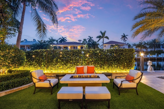 patio terrace at dusk with a lawn and an outdoor fire pit