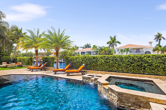 view of swimming pool with an in ground hot tub, a patio, and pool water feature