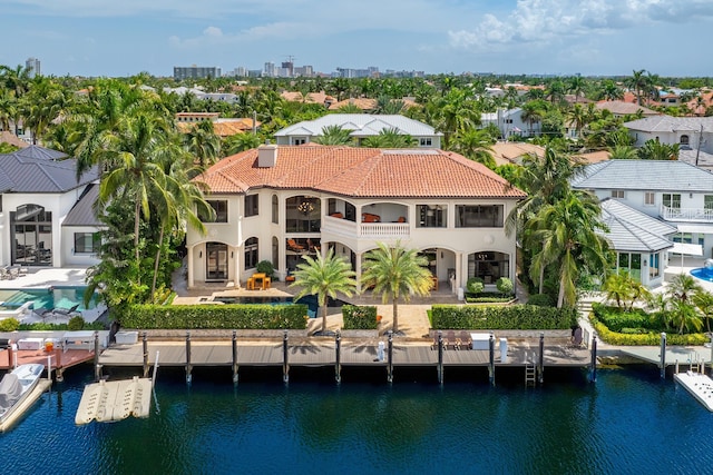 rear view of property featuring a balcony, a water view, and a patio