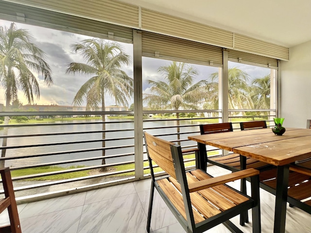 sunroom / solarium featuring a water view