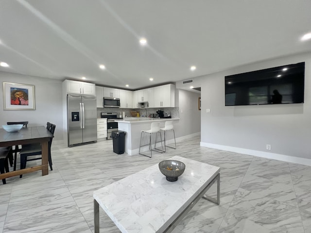 living room with marble finish floor, visible vents, baseboards, and recessed lighting