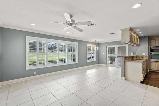 kitchen with ornamental molding, light stone countertops, sink, and light tile patterned floors