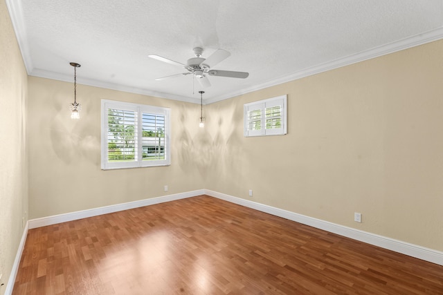 spare room with hardwood / wood-style floors, crown molding, a textured ceiling, and ceiling fan