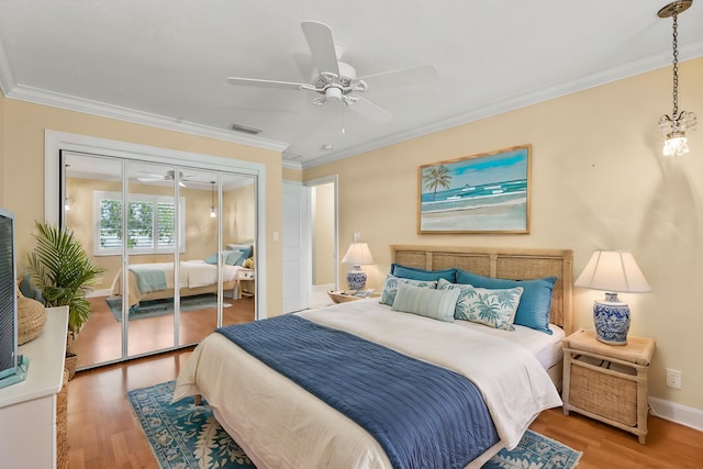 bedroom featuring hardwood / wood-style flooring, crown molding, and a closet