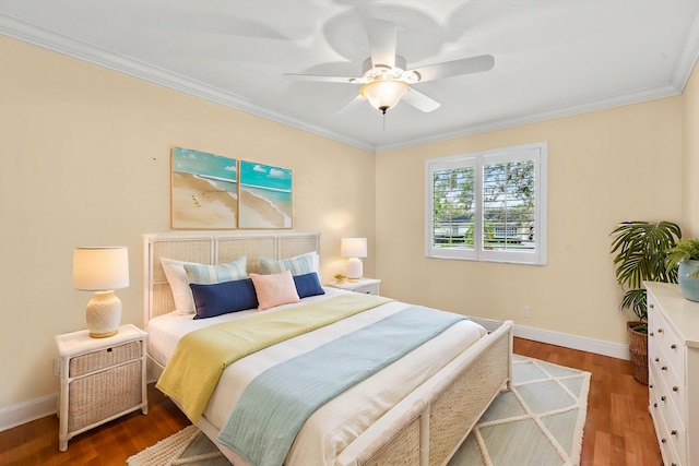 bedroom featuring crown molding, wood-type flooring, and ceiling fan