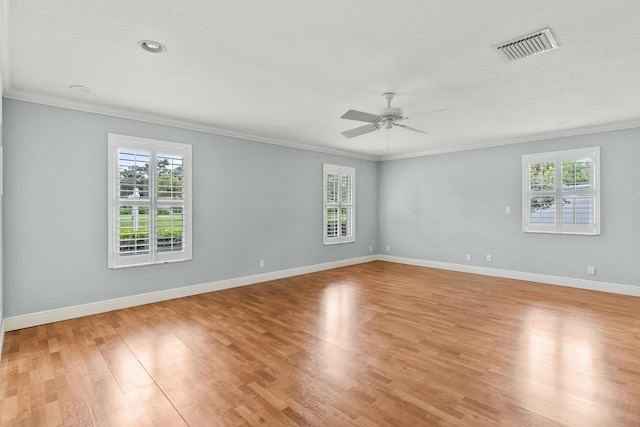 spare room featuring ornamental molding, a healthy amount of sunlight, and light wood-type flooring