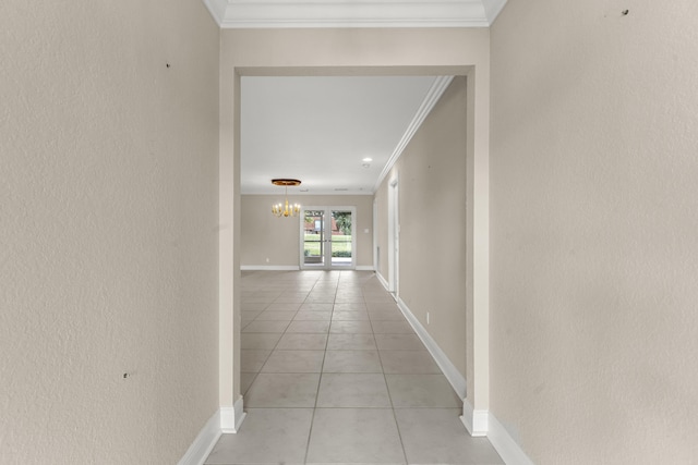 hallway with light tile patterned floors, ornamental molding, and a chandelier