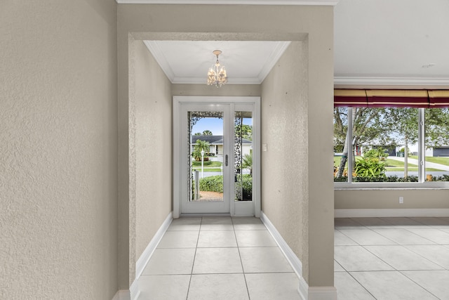 tiled foyer with ornamental molding and a chandelier