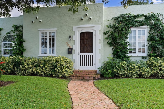 property entrance featuring a lawn