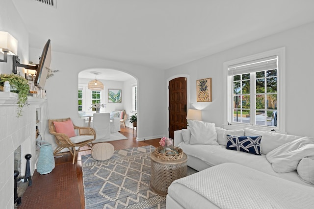 living room with hardwood / wood-style flooring and a tiled fireplace