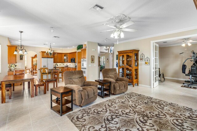 living area featuring baseboards, stairs, visible vents, and a chandelier