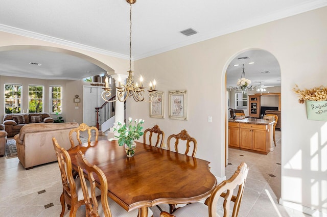 dining area with arched walkways, visible vents, a chandelier, and stairway