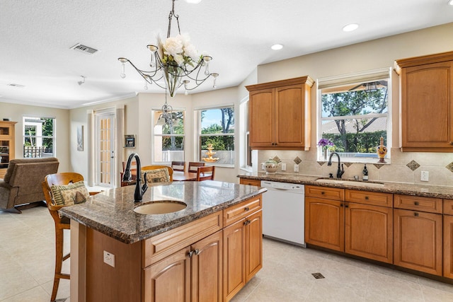 kitchen with a sink, visible vents, white dishwasher, and an inviting chandelier