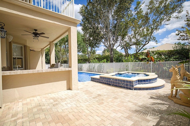 view of swimming pool with a fenced backyard, a fenced in pool, a ceiling fan, an in ground hot tub, and a patio area