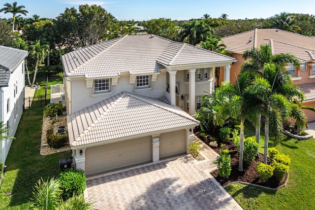 view of front of property featuring stucco siding, a tile roof, an attached garage, and driveway