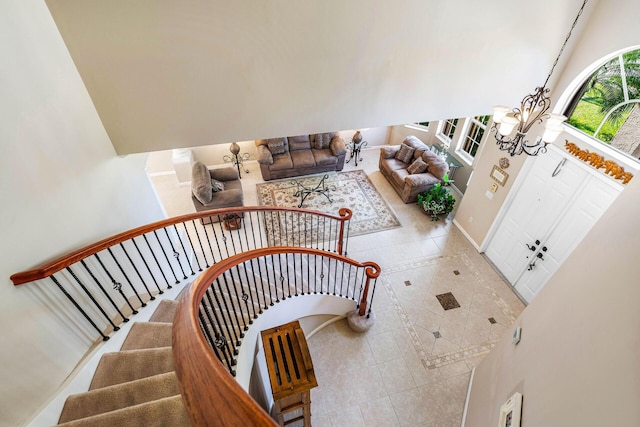 stairway with tile patterned flooring and a notable chandelier