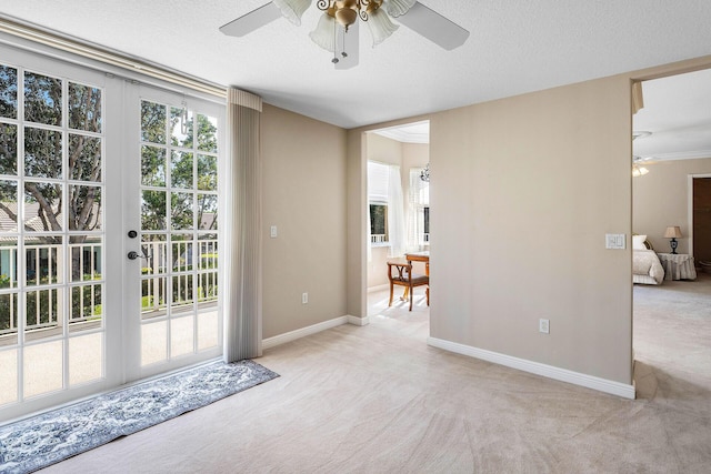 entryway with a ceiling fan, carpet, baseboards, and a textured ceiling