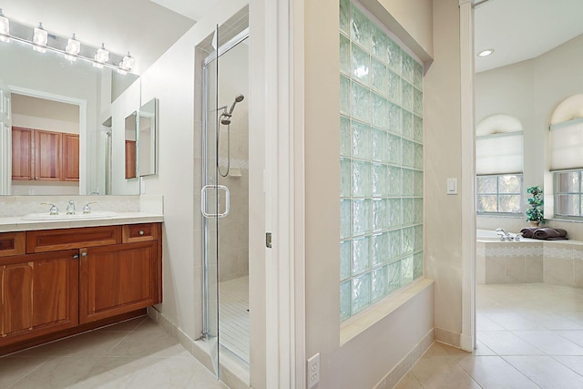 bathroom featuring a bath, a stall shower, tile patterned flooring, and vanity