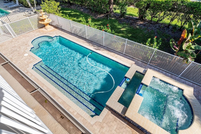 view of swimming pool featuring fence, a fenced in pool, and a hot tub