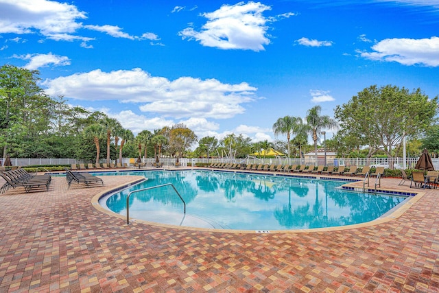 pool with fence and a patio