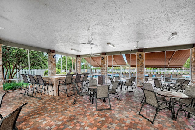 view of patio with fence, a ceiling fan, and outdoor dry bar