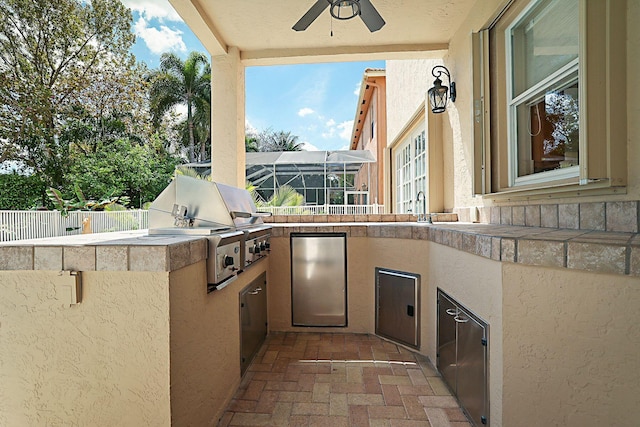 view of patio with fence, area for grilling, and ceiling fan