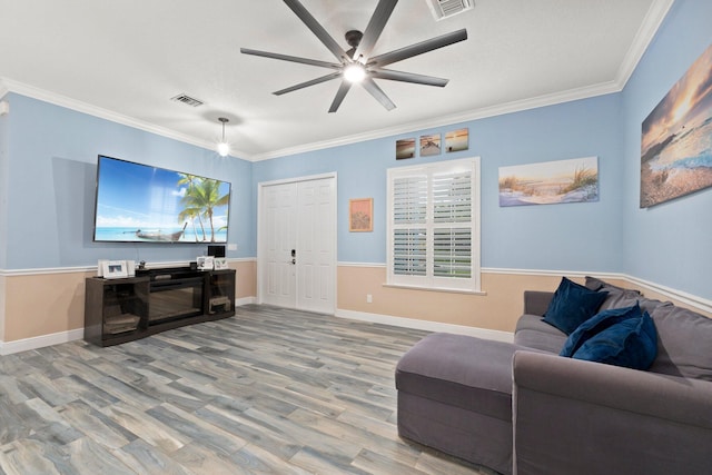 living room featuring hardwood / wood-style floors, ornamental molding, and ceiling fan