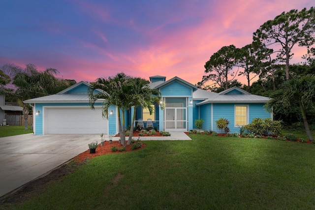 ranch-style home with a garage and a yard