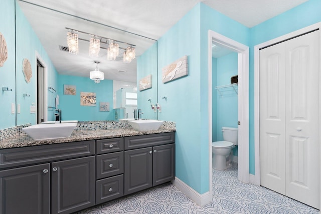 bathroom featuring tile patterned floors, vanity, toilet, and a textured ceiling