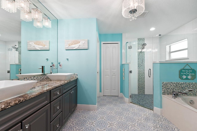 bathroom featuring tile patterned flooring, a notable chandelier, separate shower and tub, and vanity