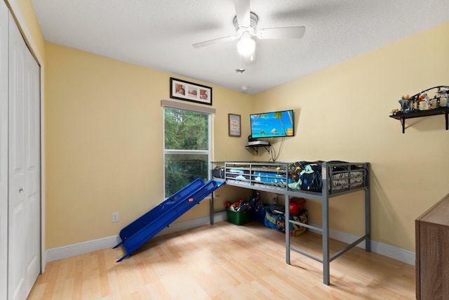 bedroom featuring hardwood / wood-style flooring, ceiling fan, a textured ceiling, and a closet