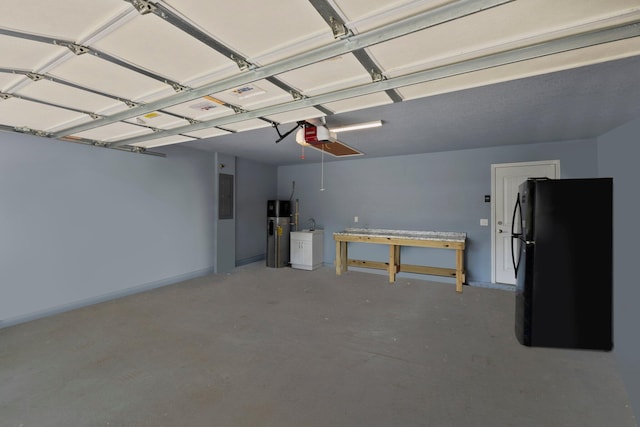 garage with water heater, black refrigerator, a garage door opener, and electric panel