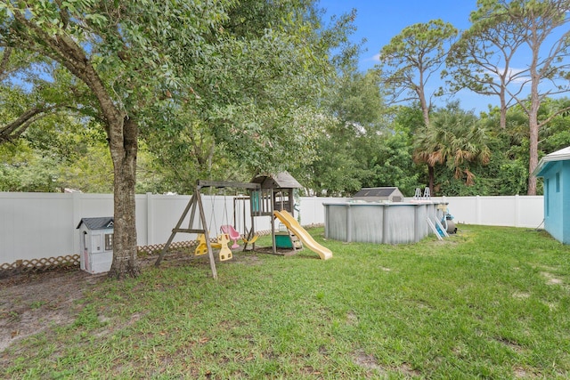 view of yard with a fenced in pool and a playground